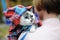 Beautiful white blue-eyed cat in a plaid shirt in a hood on the shoulder of the girl owner. Close up portrait
