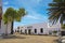 Beautiful white calm canarian town, traditional restaurant house, empty square with palm trees, blue sky