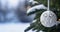 Beautiful white Christmas ornament in the tree. Blurred winter snowy bckground with copyspace. Nature aesthetic