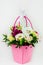 Beautiful white Eustoma Gypsophila flowers bouquet in pink pastel basket dark background. Floral gift blooming wallpaper