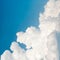 Beautiful white fleecy cloud on blue sky background. Squared image.