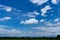 Beautiful white fluffy cloud formation on vivid blue sky in a sunny day above a wide famer agriculture land of rice plantation