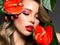 Beautiful white girl with red  flowers. Stunning girl with  Anthurium red. Closeup face of young beautiful blonde woman with a