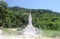 A beautiful white house of spirits in the form of carved tower on the mountain road through the jungle in Koh Samui in Thailand