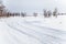 A beautiful white landscape of a snowy winter day with tracks for snowmobile or dog sled