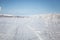 A beautiful white landscape of a snowy winter day with tracks for snowmobile or dog sled