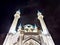 Beautiful white mosque with minarets against a dark cloudy sky in night or evening. Ramadan Holiday