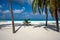 Beautiful white sandy beach with palm trees and a hammock for a wonderful vacation