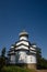 The beautiful white temple of the Kazan Skete of the Valaam Monastery. Vertical photo of temple against the blue sky on a summer