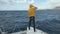 Beautiful white yacht breaks the waves. Man stands on the bow of the yacht. Clear blue water around Canary islands in