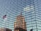 Beautiful wide shot of glass skyscraper building with the American flag and tall building reflection