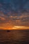 Beautiful wide twilight sunset evening sky reflect on sea water with silhouette boat in ocean and epic cloud pattern background