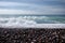 Beautiful wild pebble beach with blue sea and waves