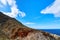 Beautiful wild red cliffs, clear blue sky, clouds. Diagonal view. Typical Greek landscape. Akrotiri peninsula, Chania