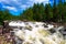 Beautiful wild river in the Arctic forest. The rapid flow carries its waters