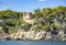 Beautiful wild rocks with castle Sant Joan and coniferous trees on Mediterranean coast
