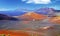 Beautiful wild rough surreal volcanic valley landscape, red volcano crater, lava ash field, clear blue sky - Timanfaya NP,