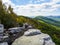 The beautiful wilderness with wooded mountains and early fall cclors with rocks in the foreground as seen from Big Schloss via