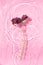 Beautiful wilted rose floating in water on pastel pink background