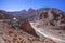 Beautiful winding road through mountains with river in summer