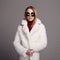 Beautiful winter girl in white fur and sunglasses. winter fashion.young woman