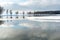 Beautiful winter landscape forest on the lake shore on a sunny frosty day. Panorama of the coastline covered with snow and birch