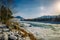 Beautiful winter landscape, mountain river valley in fantastic sunlight. Turquoise river runs among snow-covered banks