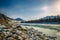 Beautiful winter landscape, mountain river valley in fantastic sunlight. Turquoise river runs among snow-covered banks