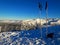 Beautiful winter landscape. Snow on the mountain with blue sky background. Ski poles with winter gloves next to them. Wonderful