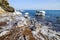 Beautiful winter landscape. snowy coast, large stones in ice on the beach, deep blue sea and clear sky. Russia, Vladivostok. East