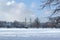 Beautiful winter landscape with snowy trees in a park with towers of the Bavarian State Chancellery in the background