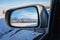 beautiful winter landscape with Tien Shan mountains and trees in field in snow in rearview mirror of car. Concept of festive