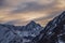 Beautiful winter mountain landscape at the sunrise with dramatics clouds. High snow covered mountains in the fog.