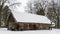 Beautiful winter nature background. Rural landscape with an old barn. Thatched roof barn covered in snow in winter.