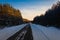 Beautiful winter road through snowy fields,sunset and forests