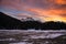 Beautiful winter sunset with orange cloud sky and snow Alps mountains and forest in Engadine region