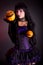 Beautiful witch in purple gothic Halloween costume