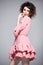 Beautiful woman with afro hair style wearing a pink dress ruffles.