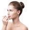 Beautiful woman applying hygienic lip balm.