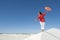 Beautiful woman balancing on sand dune rim