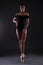 Beautiful woman ballerina in black body suit posing on toes over