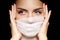 Beautiful woman with bandage face mask. Fashion eye make-up. Beauty surgery or protection hygiene in covid-19 pandemic