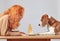 Beautiful woman and a Beagle sit at a table and look at a piece of cheese