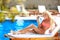 Beautiful woman bikini model tanned and lying on deck chair