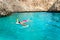 Beautiful woman in bikini snorkeling in tropical sea near cliffs