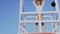 Beautiful woman in bikini standing at the lifeguard station, lifeguard tower.