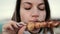 Beautiful woman biting huge pieces of meat eating with hands angry inappropriate in close up view