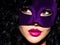 Beautiful woman with black hairs and violet theatre mask on fac