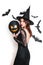 beautiful woman in black witch halloween costumes with balloon on party over white background