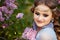 Beautiful woman in blooming lilac garden. Close up Portrait in sunset light